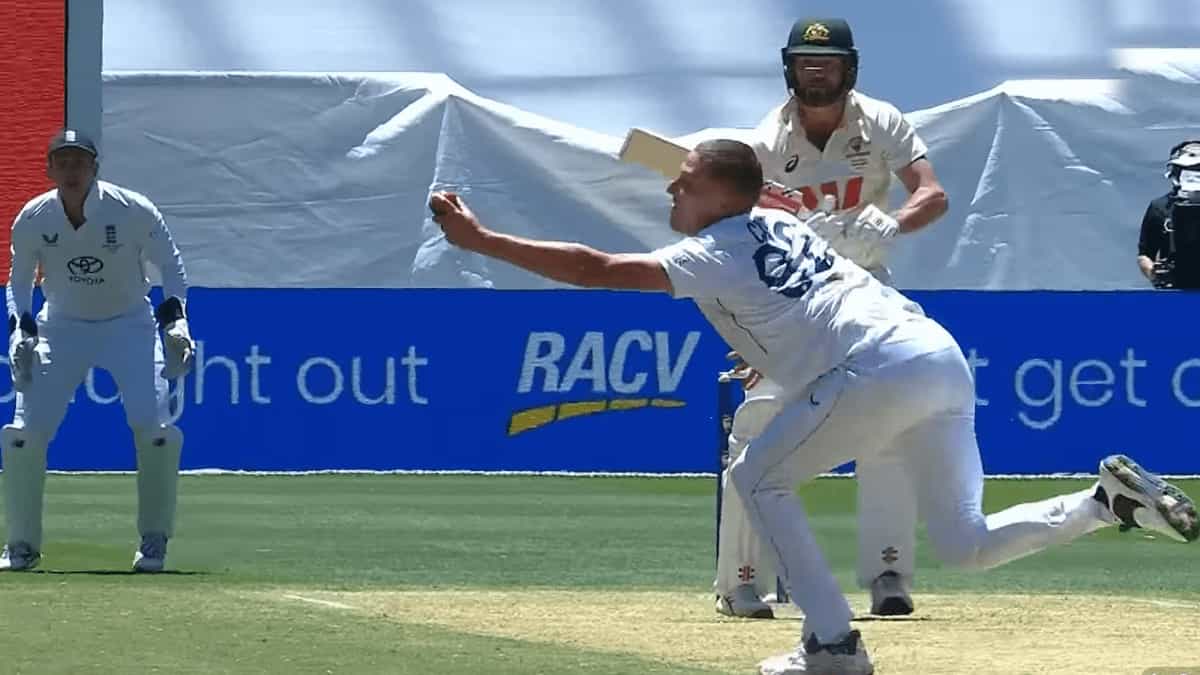 England bowler dives forward to take a catch during the Ashes Test against Australia, with the batter watching from the crease.