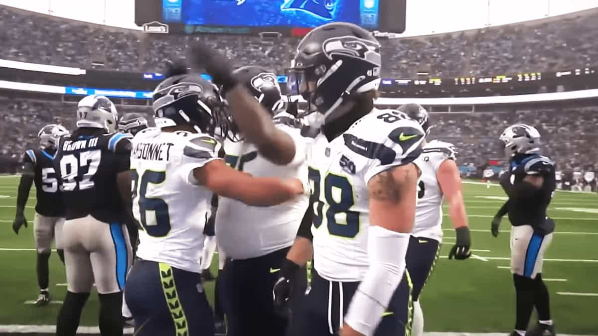 Seattle Seahawks players celebrate after a scoring play against the Carolina Panthers during the Week 17 game, as teammates gather on the field following a gritty defensive battle.