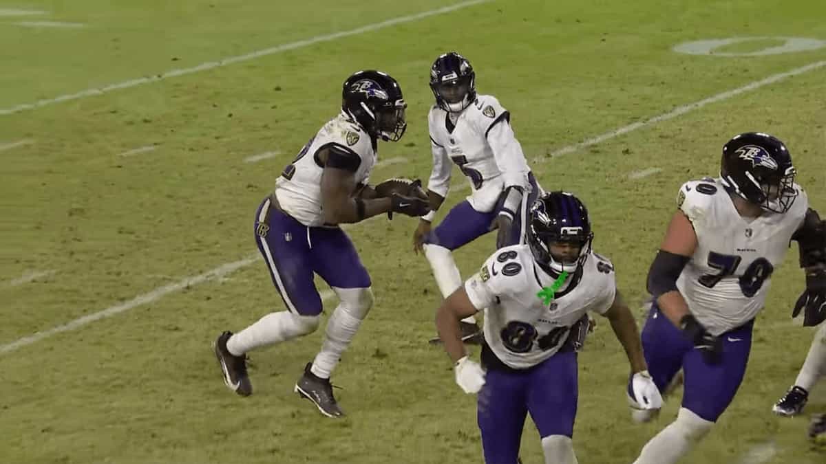 Baltimore Ravens quarterback Tyler Huntley (#2) hands the ball off to Derrick Henry during the Week 17 win against the Green Bay Packers at Lambeau Field.