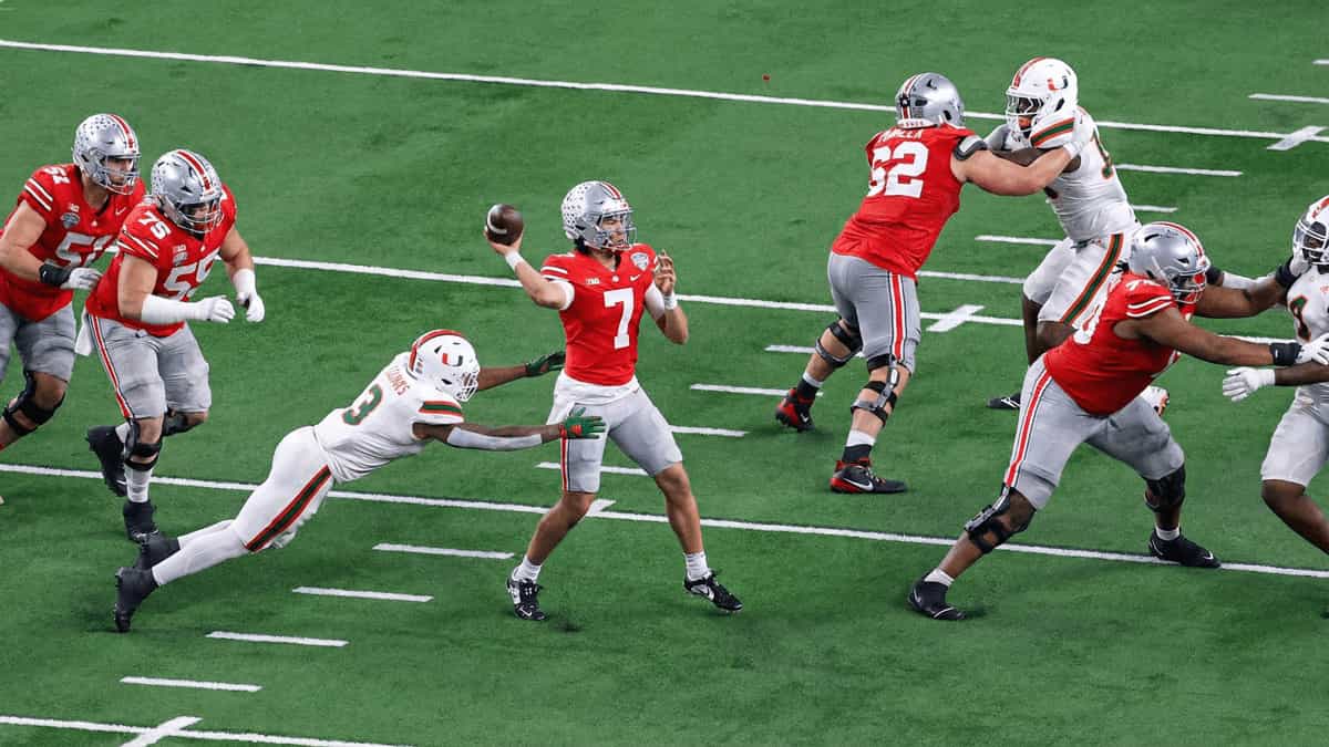 Miami Hurricanes defender diving toward Ohio State quarterback under pressure during Cotton Bowl matchup football action scene.
